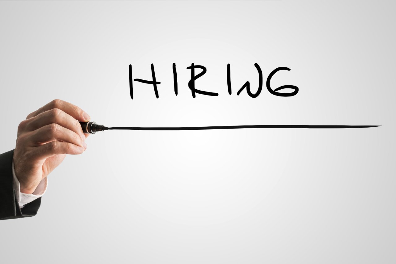 A hand underlines the word: Hiring.