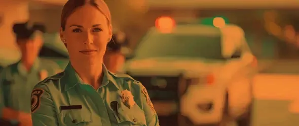 A police officer standing beside a patrol car